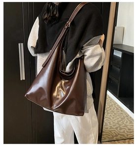 Detail of chocolate brown leather tote bag showing large capacity and shiny finish