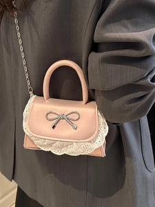 Borsa a tracolla rosa con fiocco argento e pizzo su modella in blazer grigio