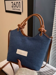Sac seau minimaliste en jean avec poignées en cuir marron et bandoulière réglable