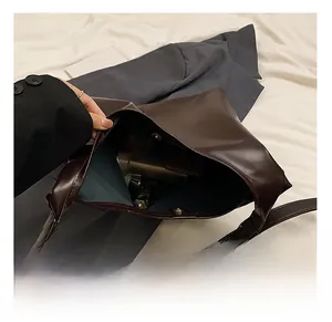 Detail of spacious dark brown tote bag interior with magnetic clasp and blue lining