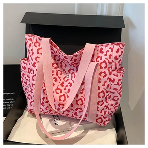 Detailed shot of pink canvas tote bag with red leopard print and side pockets