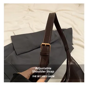 Detail view of adjustable dark coffee leather shoulder strap with gold buckle