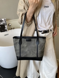 Retro canvas and leather tote bag with FASHION label shown on an elegant model