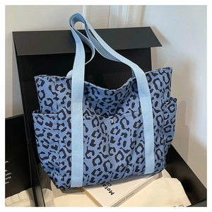 Detail of light blue leopard print tote bag featuring canvas fabric and side pocket