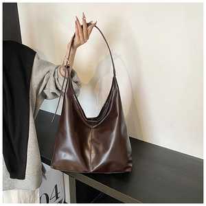 Detail view of large dark brown leather tote bag showing vertical seam and soft texture