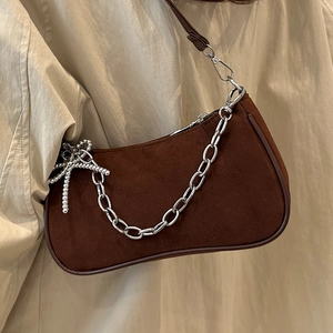 Brown frosted leather baguette bag with silver chain and beaded bow accent worn by model