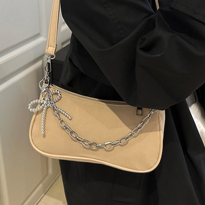 Three-in-one beige dumpling baguette bag with metal chain and bow charm detail