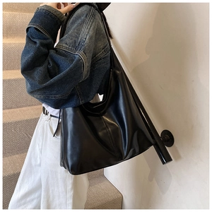 Large black matte leather tote bag shown on shoulder for daily commute look
