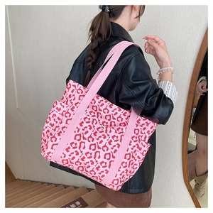 Detailed back view of pink leopard print canvas tote bag carried over the shoulder