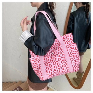 Detail of pink leopard print tote bag featuring multiple exterior side pockets and shoulder straps