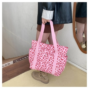Close-up of pink leopard print tote bag with multi-pocket design and wide canvas handles