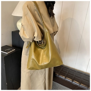 Olive green hobo bag with wide shoulder strap shown in a minimalist interior setting