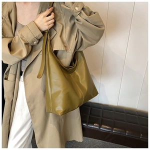 Detail of olive green oversized hobo bag featuring glossy faux leather and vertical stitching