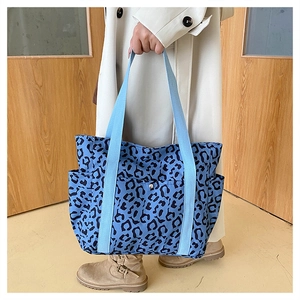Detail of blue leopard print tote bag with wide strap and convenient side pocket