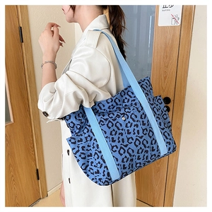 Close-up of blue leopard print tote bag with light blue wide strap and side pocket