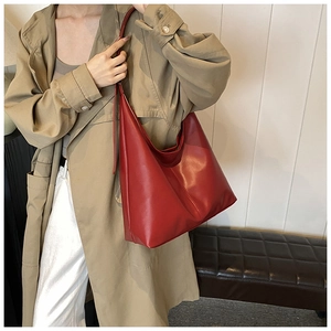 Red large capacity tote bag shown on model with neutral trench coat and casual trousers