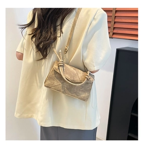 Detail of gradient crossbody bag featuring knotted handles and vintage wrinkled texture