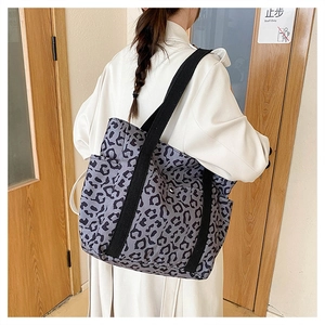 Detail of grey leopard print tote bag featuring wide fabric straps and side pockets