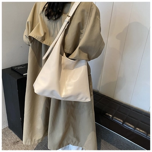 Detail of cream white PU leather tote bag featuring vertical stitching and adjustable strap