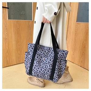 Detailed close-up of large leopard print tote bag with front pocket and side pockets