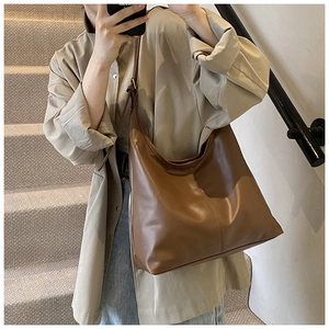 Detailed close-up of dark brown PU leather tote bag with stylish stitching for women