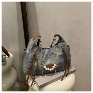 Détail d'un sac cabas en toile grise avec chaîne de perles et anses en cuir marron
