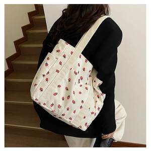 Vue latérale détaillée d'un sac cabas en velours côtelé beige à motif fraises