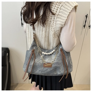Détail du sac bandoulière en toile grise avec ornements de perles et fleurs dorées