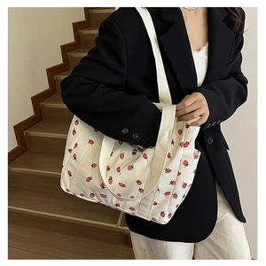 Détail du sac fourre-tout en velours côtelé blanc avec imprimé fraise et large bandoulière