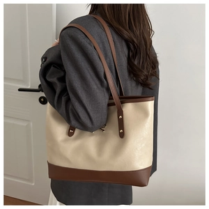 Detailed side view of a large bow-knot tote bag worn with a stylish blazer