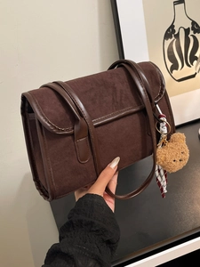 Brown frosted suede underarm bag with teddy bear charm and sleek leather trim detail