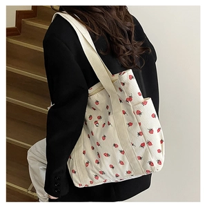 Vue détaillée d'un sac cabas en velours côtelé crème avec motifs fraises rouges vifs