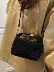 Fashionable leopard print crossbody bag with gold clasp shown on a model in khaki coat