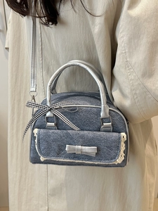 Blue denim boston bag with lace trim and silver bow handle for women's fashion
