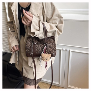 Retro leopard print handbag with plush bear charm shown on a model for size perspective