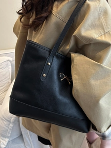 Fashionable black leather tote bag with gold bow decoration and large capacity for commuting