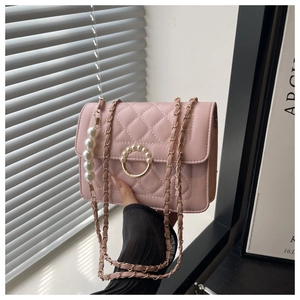 Detail of pink quilted chain bag featuring pearl buckle and gradient pearl charm