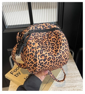 Close-up of leopard print makeup bag with black zipper and woven pull string