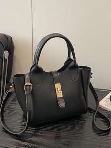 Grande borsa a secchiello in pelle nera con chiusura dorata e tracolla, stile moderno