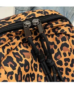 Close-up of leopard print fabric bag showing smooth dual zippers with black woven pulls