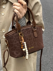 Chic leopard print handbag with golden logo, wooden bead tassel and crossbody strap