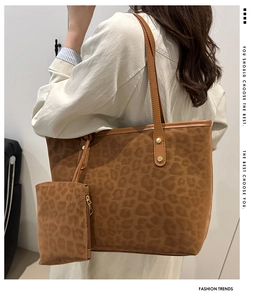 Detail view of leopard print tote bag with small matching pouch shown on shoulder
