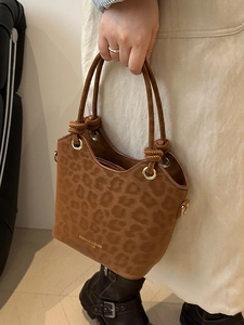 Chic brown leopard print bucket bag with dual handles and elegant gold lettering