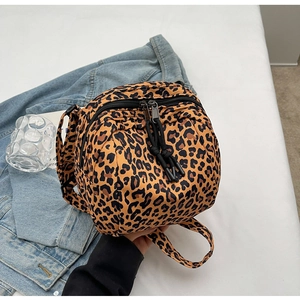 Fashionable leopard print canvas crossbody bag with dual zippers and denim jacket backdrop