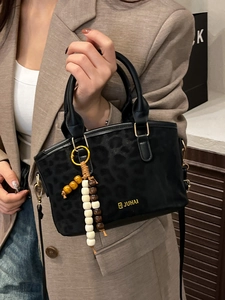 Elegant black leopard print handbag with wooden bead charm and long shoulder strap