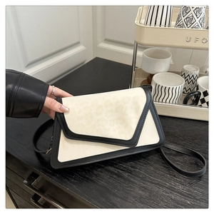 Detail of trendy cream crossbody bag with leopard print and black strap finish