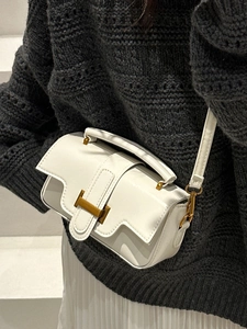 Mini sac bandoulière en cuir blanc brillant avec boucle H dorée porté par un modèle