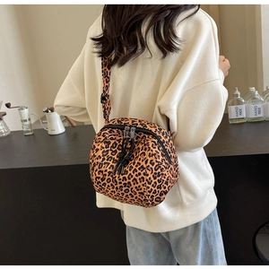 Detailed back view of model wearing a leopard print crossbody bag near a coffee station