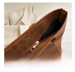 Close-up of smooth gold metal zipper and leopard print leather texture on tote bag