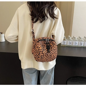 Close-up of leopard print crossbody bag showing dual metal zippers and texture